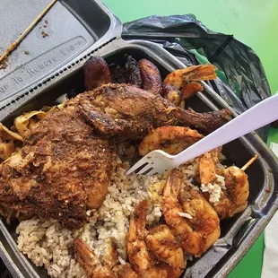 Jerk chicken/ shrimp Combo plate with cabbage and sweet plantains. The chicken/shrimp sits on a bed of rice. I highly recommend.