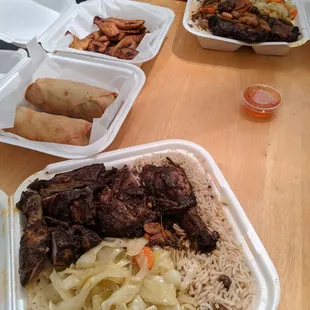 From front to back: jerk chicken, jerk egg rolls, fried plantains, oxtail