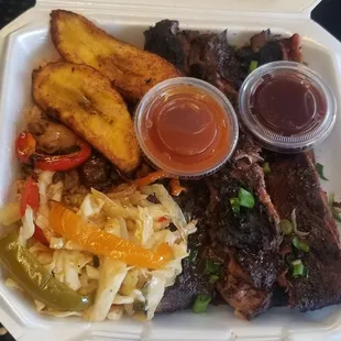 a styrofoam takeout box with a variety of food items