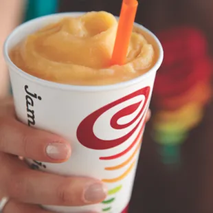 a person holding a cup of fruit juice