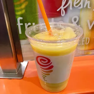 a smoothie in a plastic cup with a straw