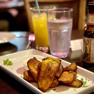 a plate of potato wedges and a glass of orange juice