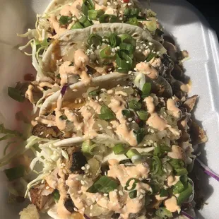 4 grilled chicken tacos with pineapple salsa, sesame seeds, and teriyaki sauce.