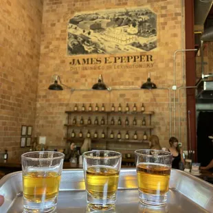 three glasses of whiskey on a tray