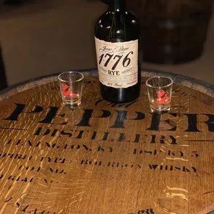 two shot glasses on a barrel