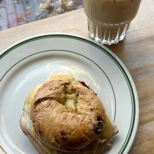 @hangry_detroiter || Stuffing sando (Turkey Breast, Cranberry Sauce, Gravy, Mayo Recommended on the Stuffing Bagel) and iced latte