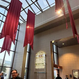 people sitting at tables with red flags hanging from the ceiling