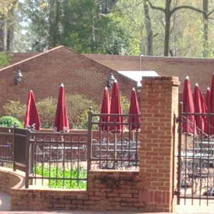 a brick patio with red umbrellas