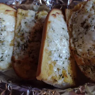 three slices of garlic bread on foil