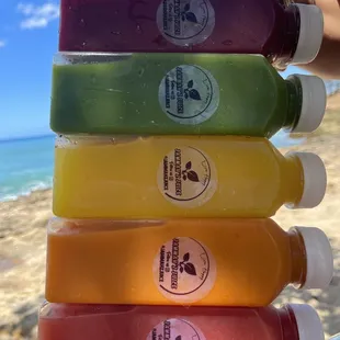 a hand holding a stack of juices