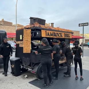 a group of people standing in front of a food truck