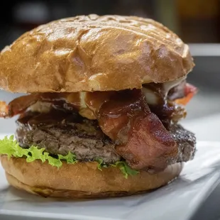 a burger with bacon and lettuce