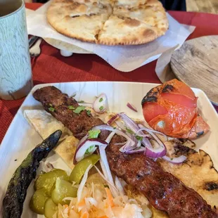 Beef kabob with side of tomato and hot pepper