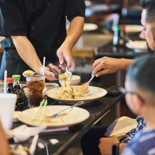 a waiter serving a meal to a group of people