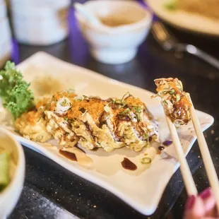 a plate of sushi with chopsticks