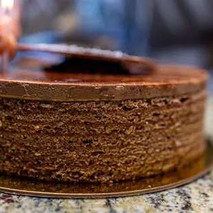 Chocolate Decadent Cake ($54) thin layers of chocolate cake and raspberry jam topped with chocolate ganache, shavings and mirror glaze
