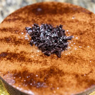 Chocolate Decadent Cake ($54) thin layers of chocolate cake and raspberry jam topped with chocolate ganache, shavings and mirror glaze