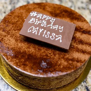 Chocolate Decadent Cake ($54) thin layers of chocolate cake and raspberry jam topped with chocolate ganache, shavings and mirror glaze