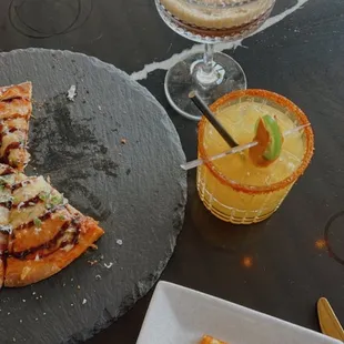 a slice of pizza on a plate next to a glass of orange juice