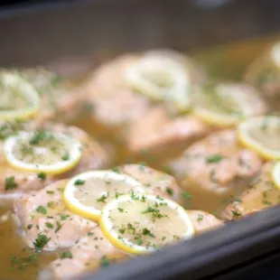 a pan of chicken with lemon slices