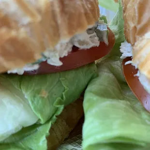 The sandwich valley between the two halves. Fresh tomato slice and crisp iceberg lettuce.