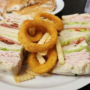 Turkey club meal with onion rings and fries