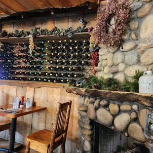 a stone fireplace with wine bottles on it