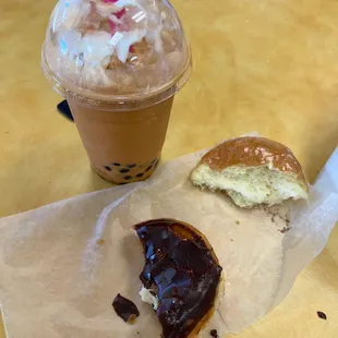 a half eaten donut and a drink