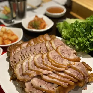 a plate of sliced meat and vegetables