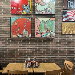 a table and chairs in front of a brick wall