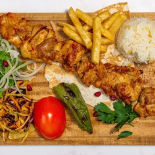 Chicken Kebab - 
Skewered chicken thighs, grilled, served with rice, french fries and veggies.