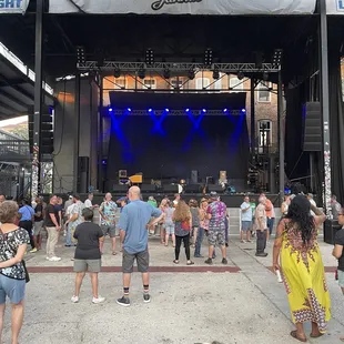 a crowd of people dancing in front of a stage