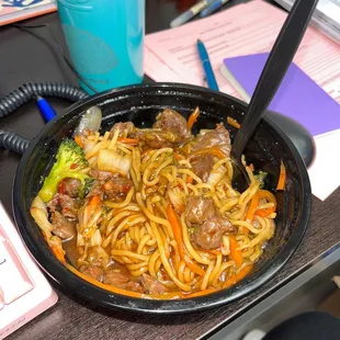 a bowl of noodles with meat and vegetables