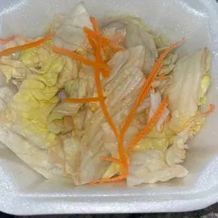 a plastic container with a salad in it