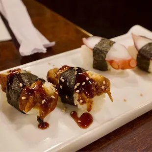 three sushi rolls on a white plate