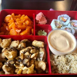 Bento box with Chicken Hibachi, fried rice, Crunchy Roll and sweet carrots.