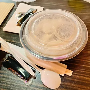 a bowl of sushi and spoons