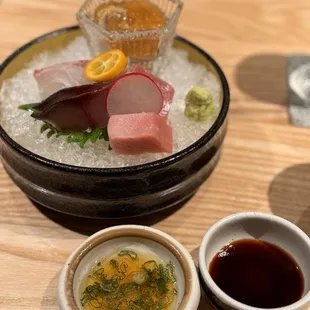 a bowl of sushi and bowls of sauces