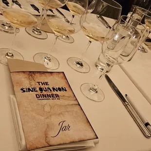 a table set with wine glasses and a menu