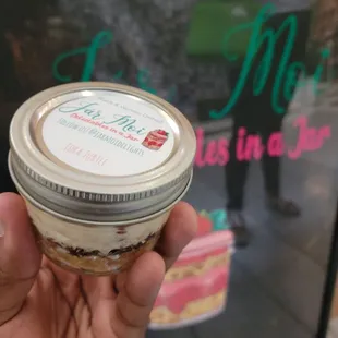 a hand holding a jar of food