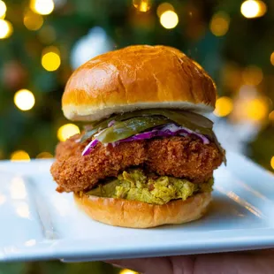 a hand holding a chicken sandwich