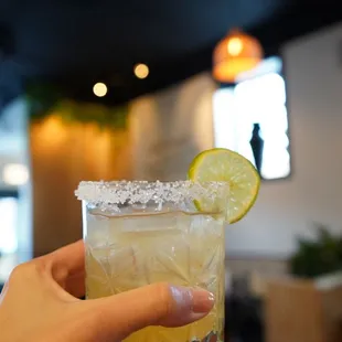 a person holding a glass of cocktail