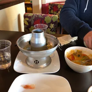 Cup of water, large Tom yum seafood soup, pumpkin curry.