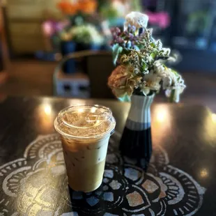 iced coffee and a vase of flowers