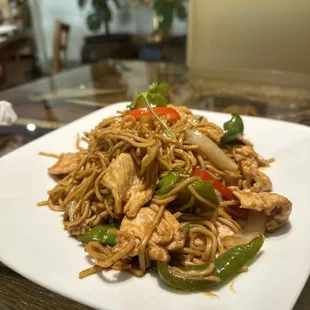 a plate of noodles with chicken and peppers
