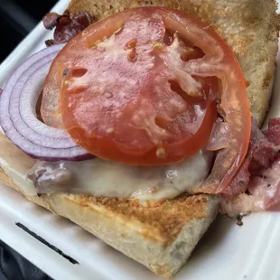 Hot pastrami on French bread with provolone, stone mustard, red onions and tomatoes