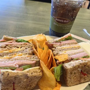 The Club Sandwich with barbecue chips and soda.