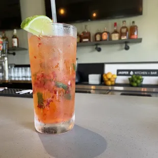 a cocktail with a lime slice