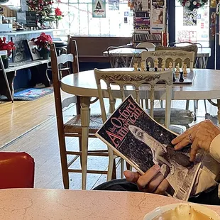 a man sitting at a table reading a newspaper