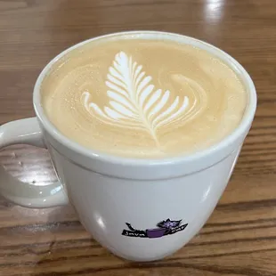 a cup of coffee on a wooden table